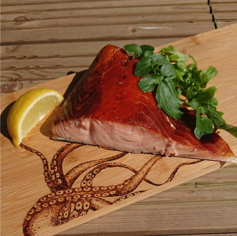 Cut fillet of hot smoked salmon on a chopping board