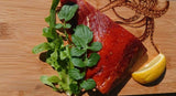 fillet of hot smoked salmon dressed on chopping board with garnish